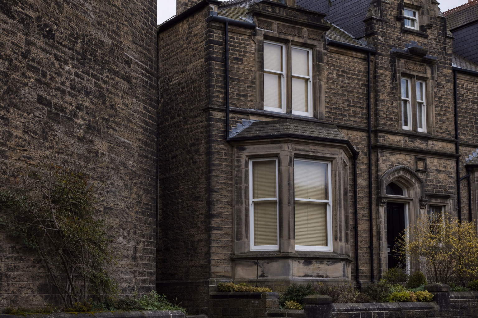 A weathered Victorian Yorkshire stone house with slate roof and traditional masonry detailing